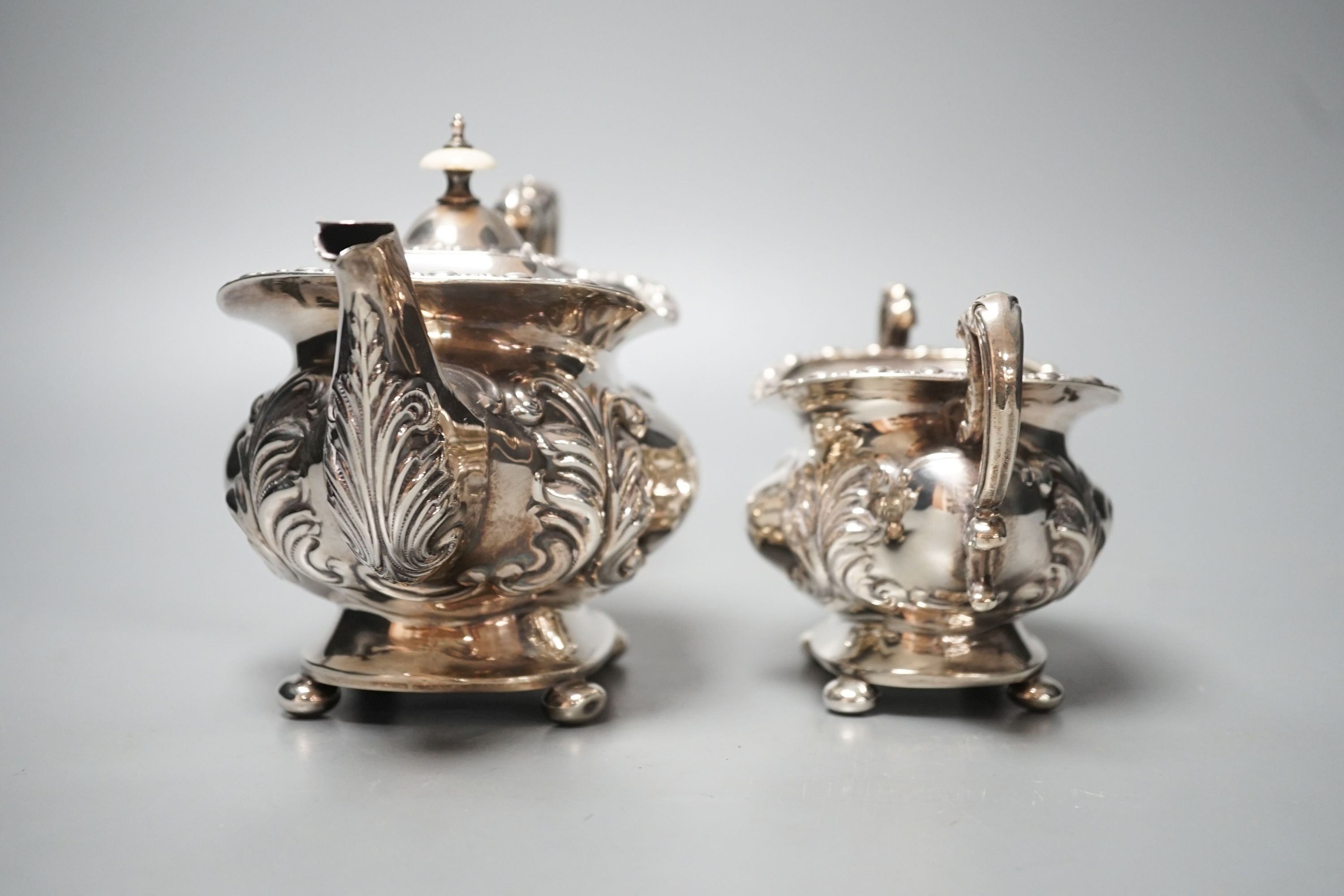 An Edwardian embossed silver teapot and matching sugar bowl, William Aitken, Chester, 1903, gross 21.5oz.